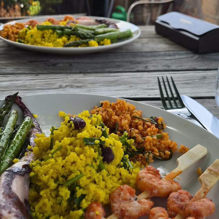 Teller mit Couscous, Bulgursalat, Spargel und Garnelen